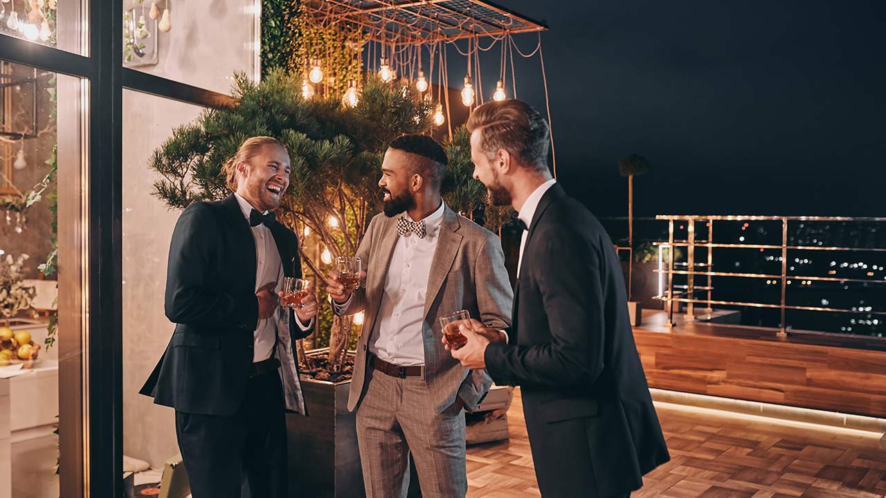 Foto de um grupo de homens com iluminação de local de festa.