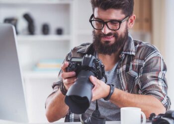 Homem segurando equipamento fotográfico.