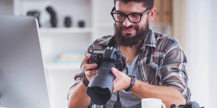 Homem segurando equipamento fotográfico.
