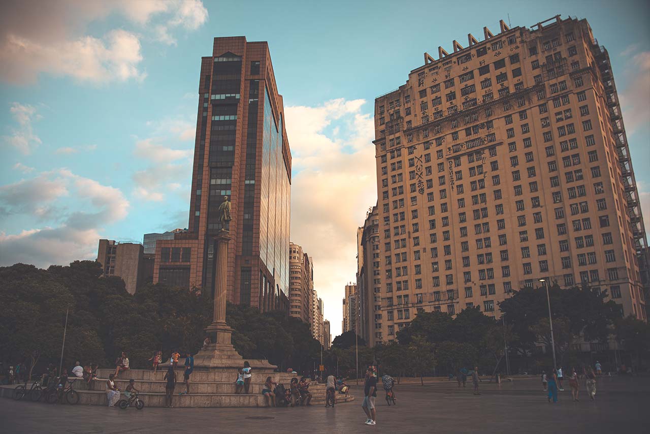 Foto de 2 prédios e uma praça.